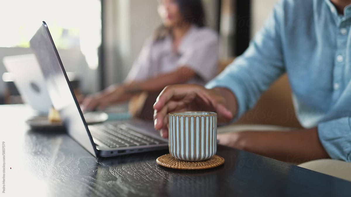 working on a laptop with a cup of coffee